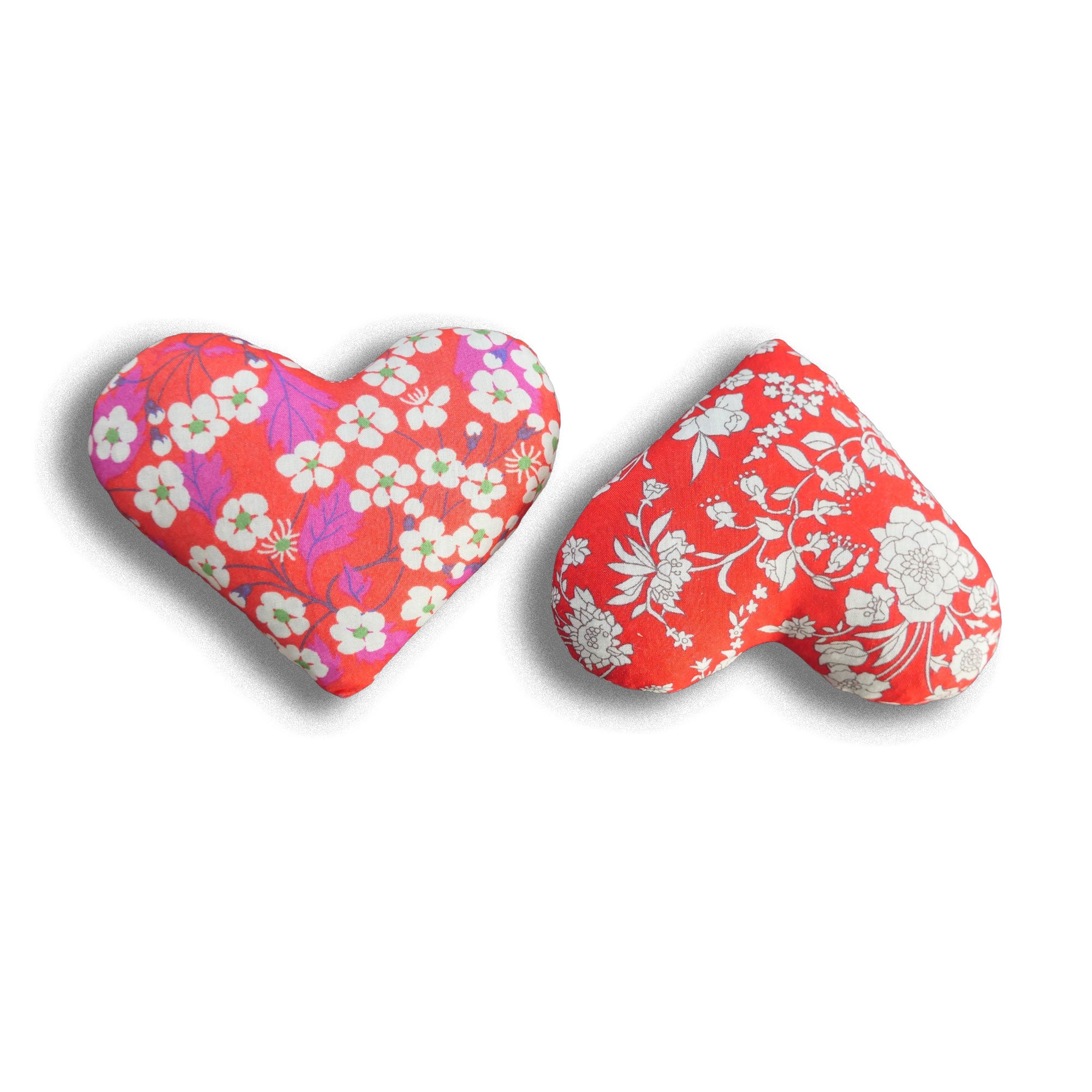 Two heart-shaped lavender bags with floral patterns on a white background