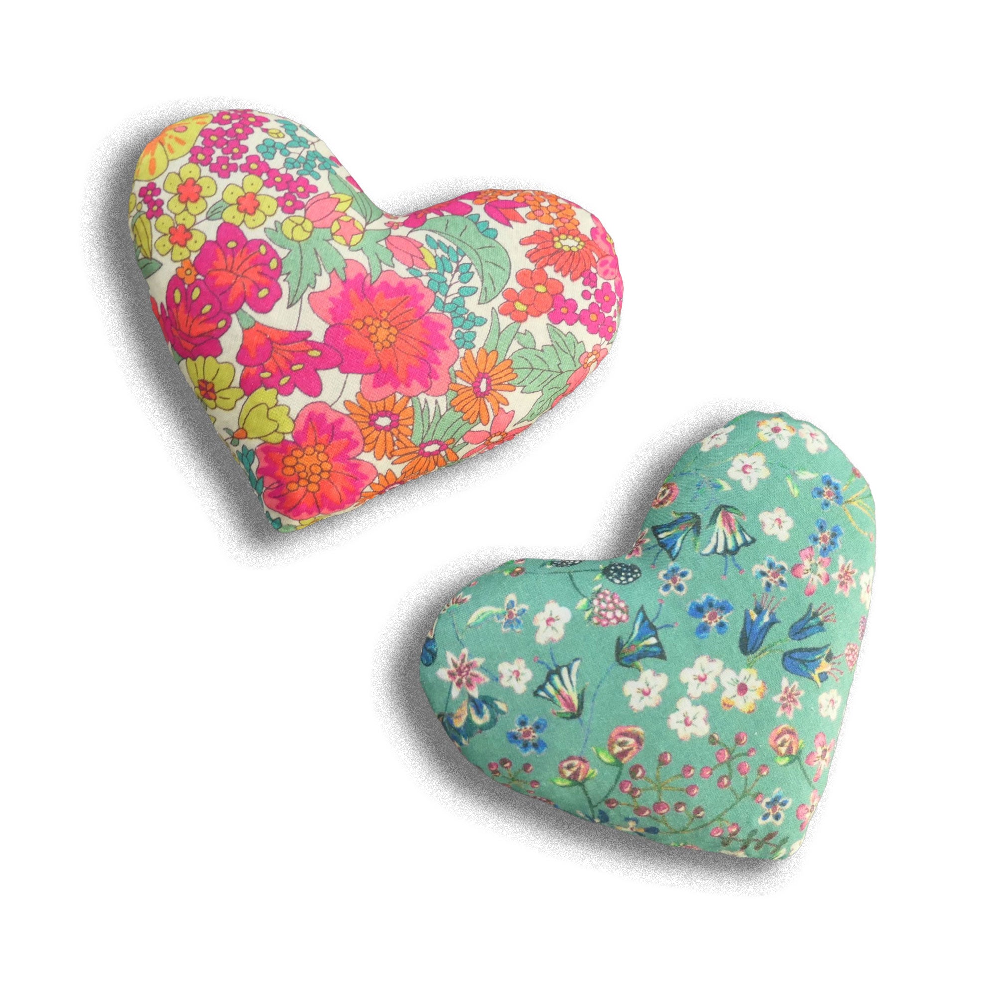 Two heart-shaped lavender sachets with floral patterns on a white background