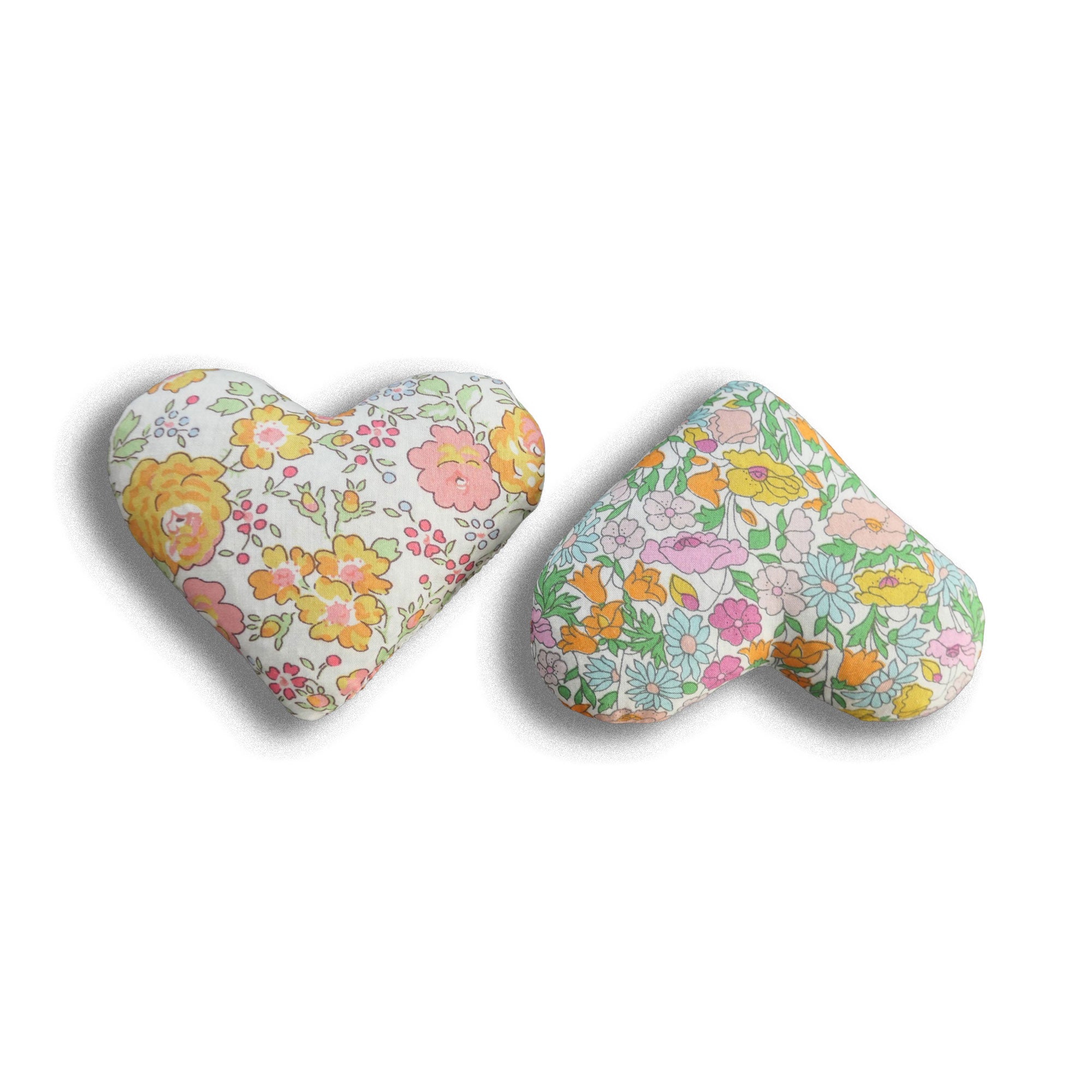Two heart-shaped lavender bags with floral patterns on a white background