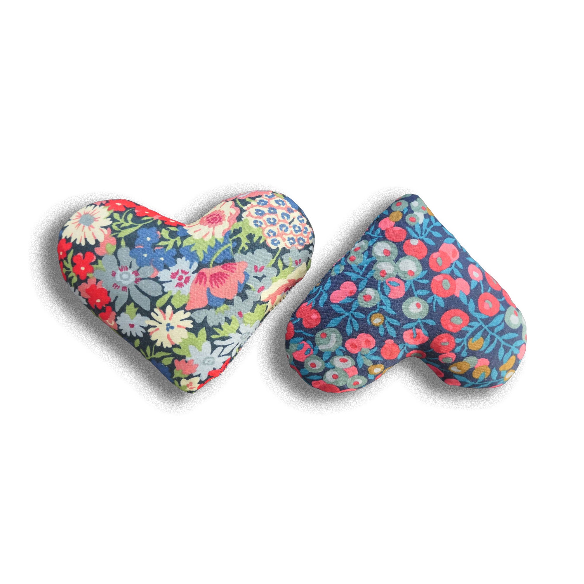 Two heart-shaped floral sachets in red and blue on a white background