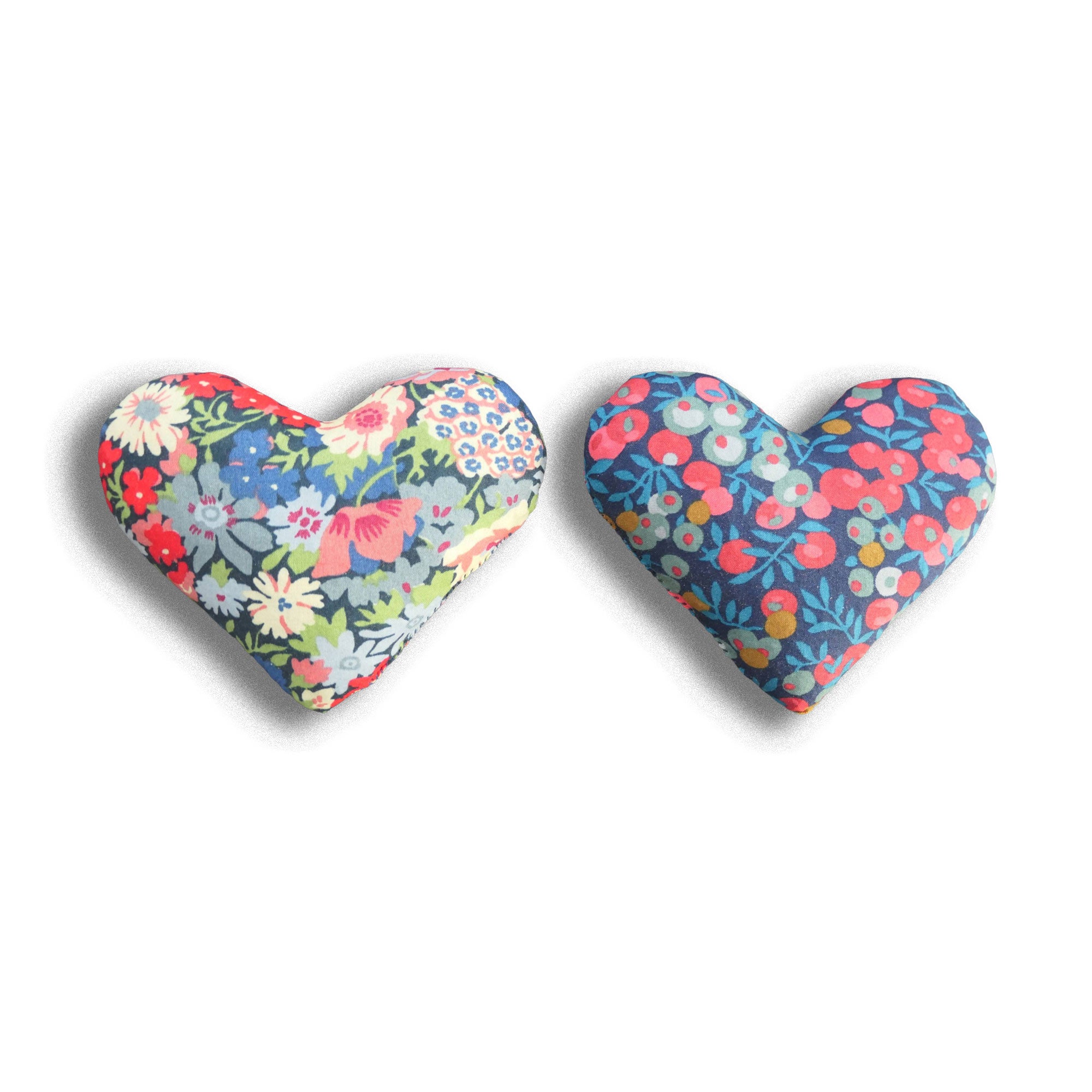 Two heart-shaped sachets with floral patterns in blue and red on a white background