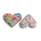 Two heart-shaped sachets with red, yellow and blue floral patterns on a white background