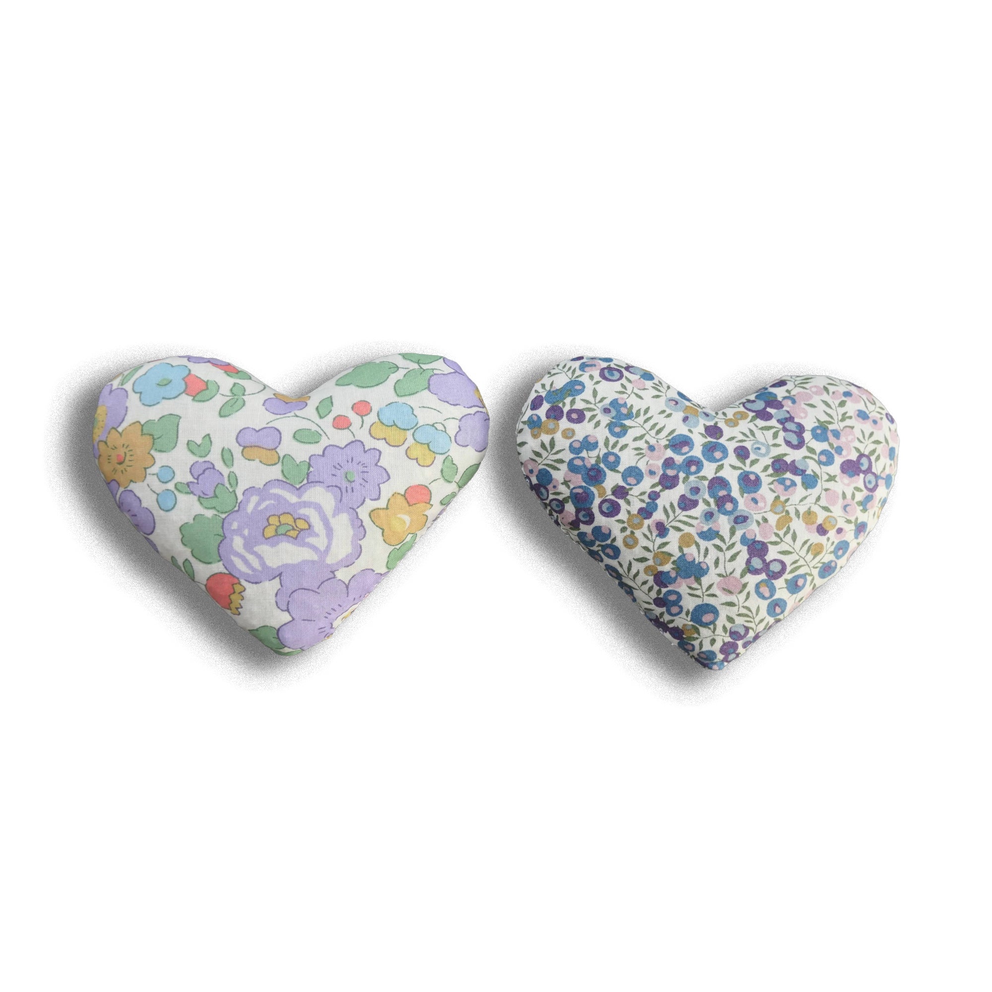 Two heart-shaped floral lavender sachets on a white background