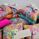 Colourful fabric pillows with floral patterns on a gray background