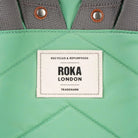 Close up of a green bag with a Roka London label 