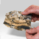 Hands holding an origami paper sheet, showing the design of the paper and the fold lines.