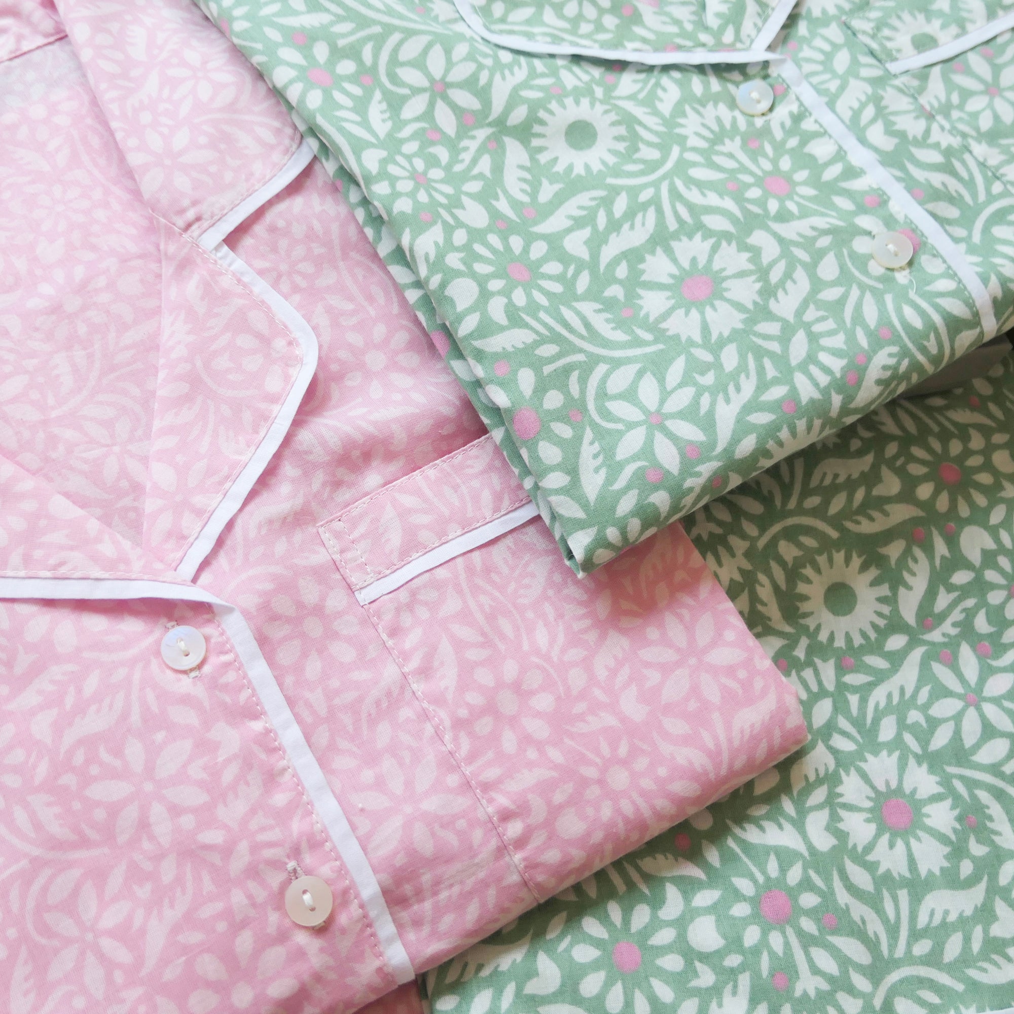 Pink and green patterned pyjamas with buttons on a white background