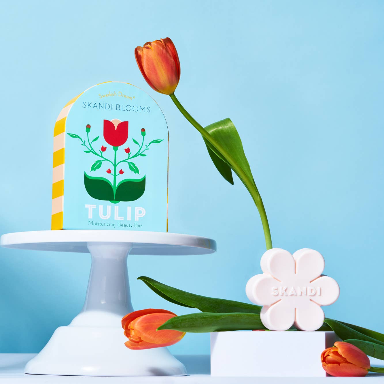 Skandi Blooms tulip product with packaging and soap on a blue background with tulip flowers 