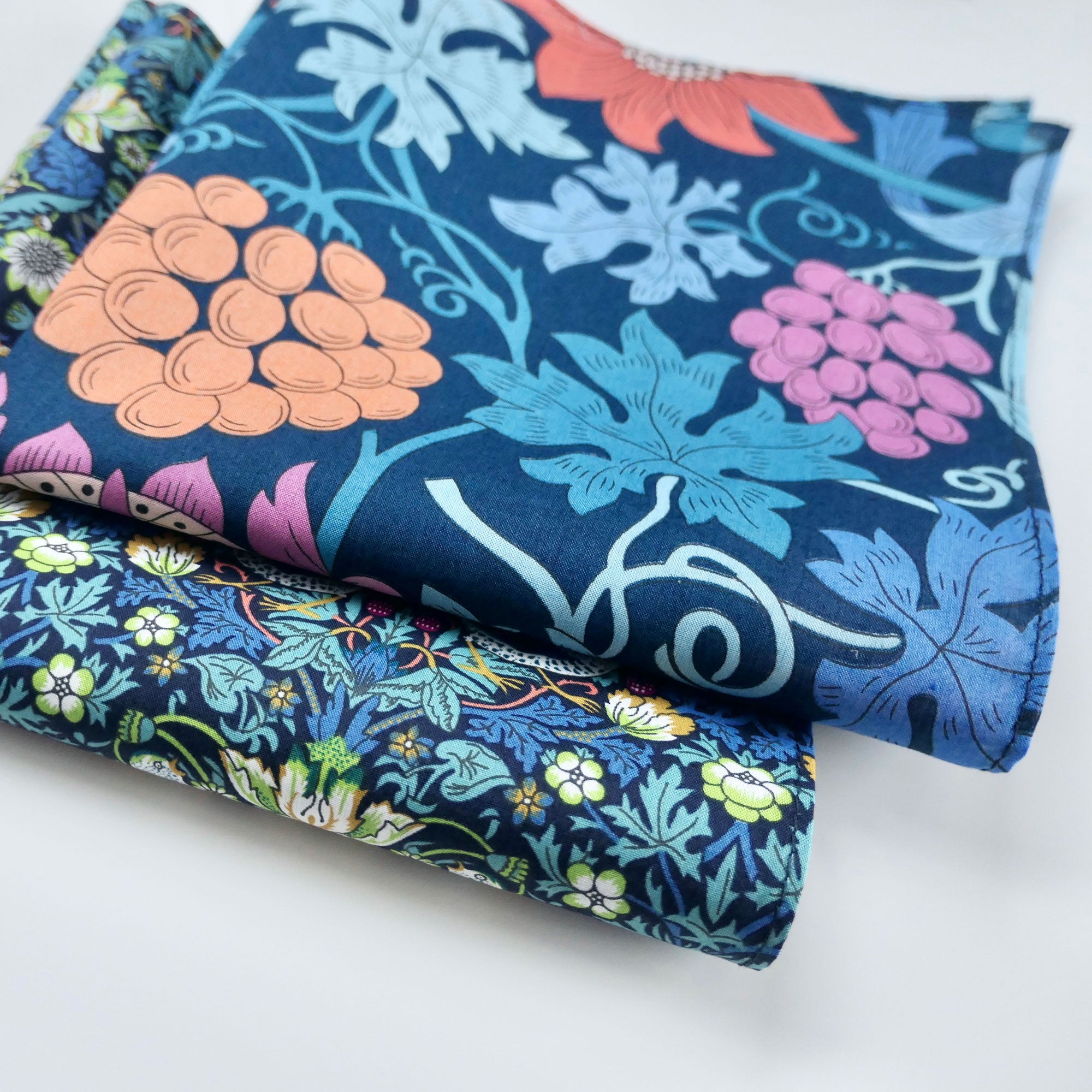 Stack of colourful floral fabric hankies on a white background