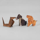 Examples of three origami dogs in various designs against a neutral background.