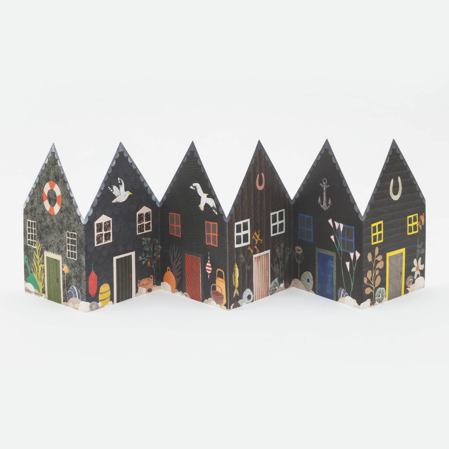Decorative paper houses with various designs on a white background