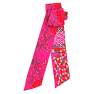 Pink patterned scarf with floral and abstract designs on a white background