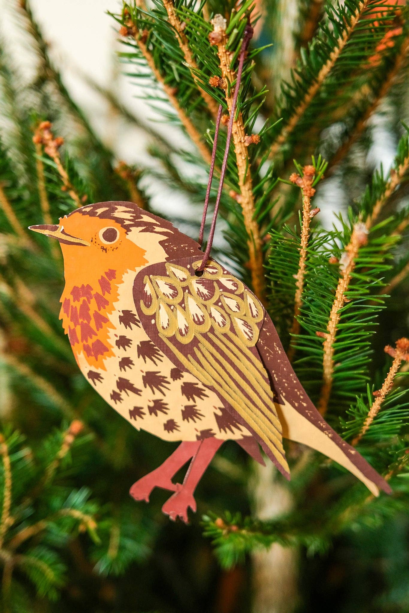 Decorative bird ornament hanging on a Christmas tree.