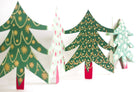 Decorative paper Christmas trees with green, red, and white patterns on a white background.