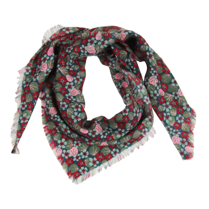 A square scarf with fringed edges featuring a dense floral pattern in red, pink, light blue, and olive green on a dark background, arranged in a loop on a white studio background.