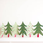 Decorative paper Christmas trees with green, red, and white patterns on a white background