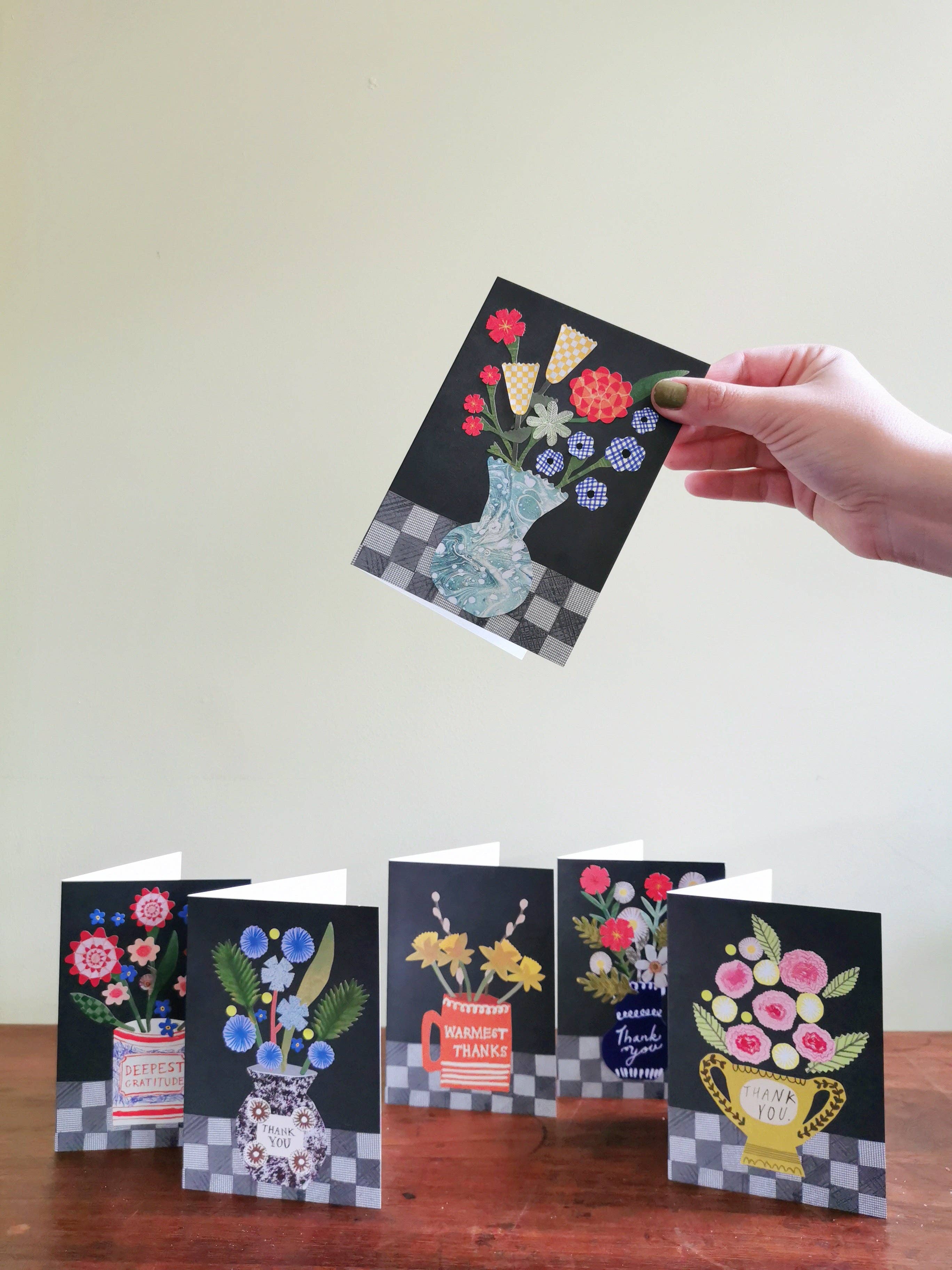 Set of greeting cards with floral designs on a wooden surface