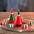 Decorative candles shaped like Christmas trees on a wooden surface