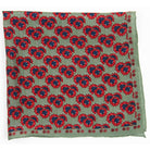 Patterned fabric with red and blue floral design on a green background