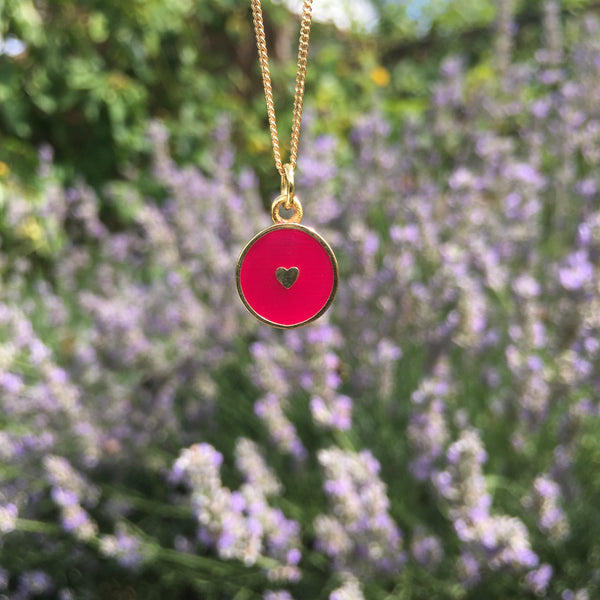 red heart necklace in front of lavender 
