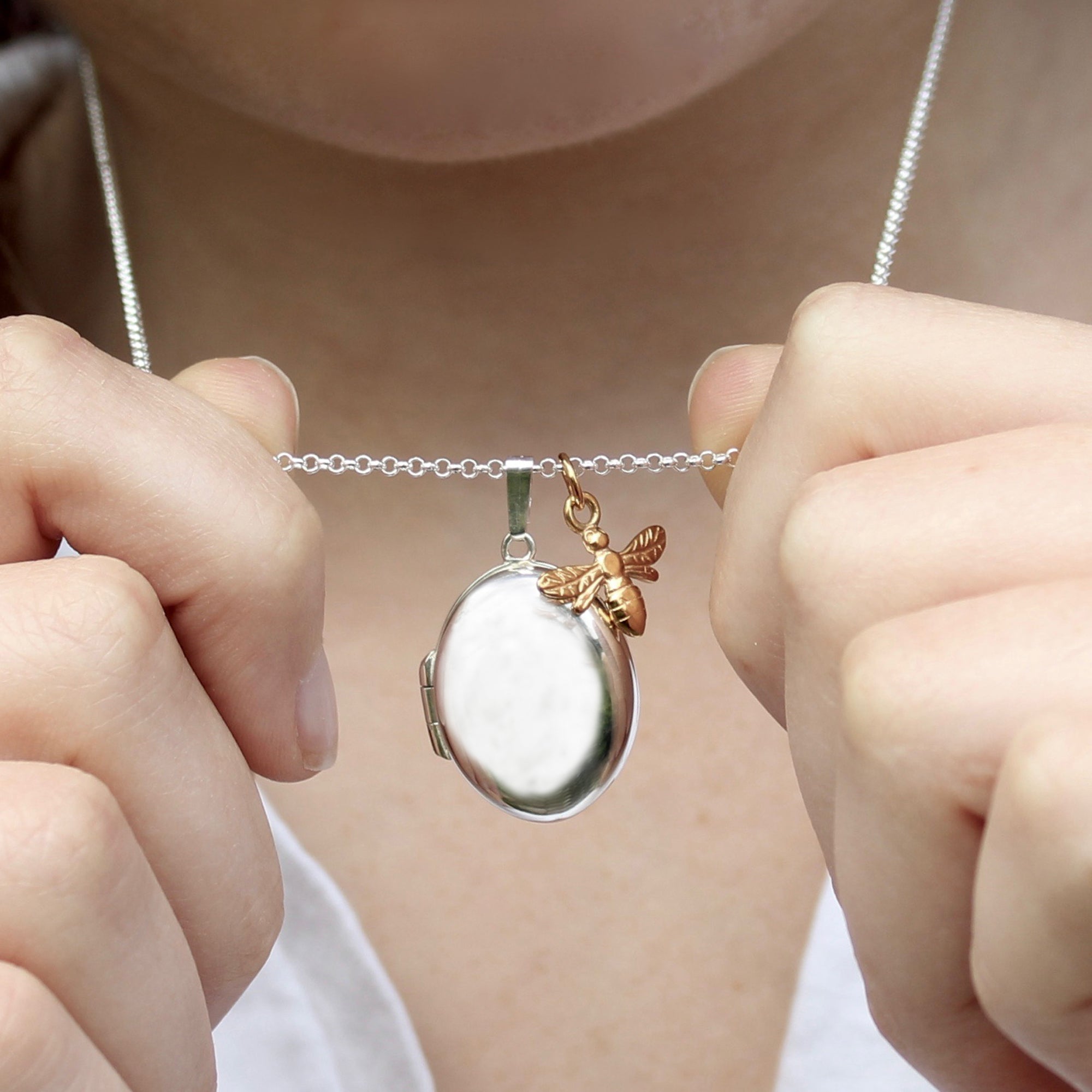 silver oval locket with gold bee